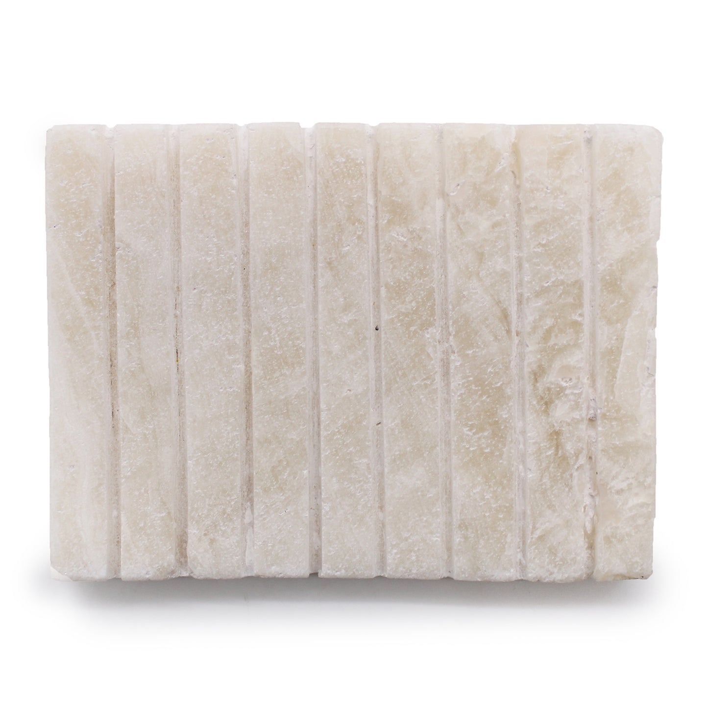 Hand-carved white onyx soap dish with ridged top surface, minimalist and elegant.