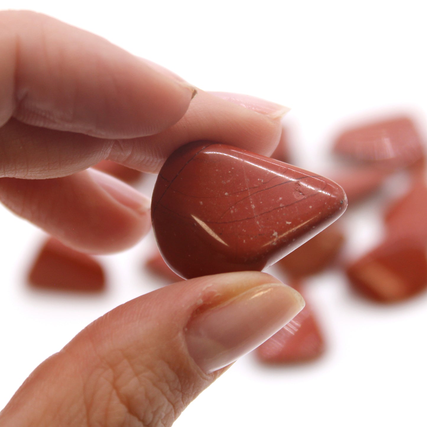 Polished Red Jasper tumbled stones (10–25 mm), known for grounding, strength, and emotional stability. Sold in a 24-piece bag.