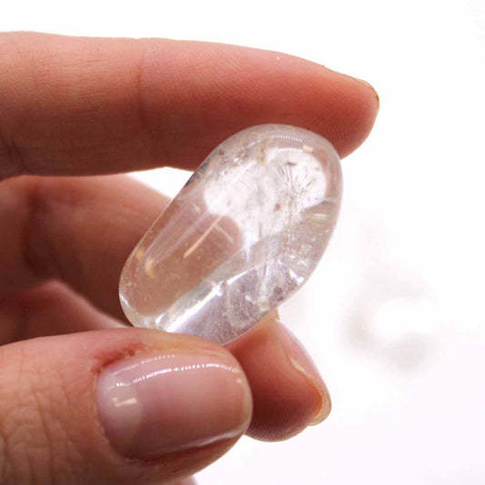 Clear Rock Crystal (Quartz) tumbled stones (10–25 mm), polished and transparent, symbolising clarity, healing, and energy amplification.