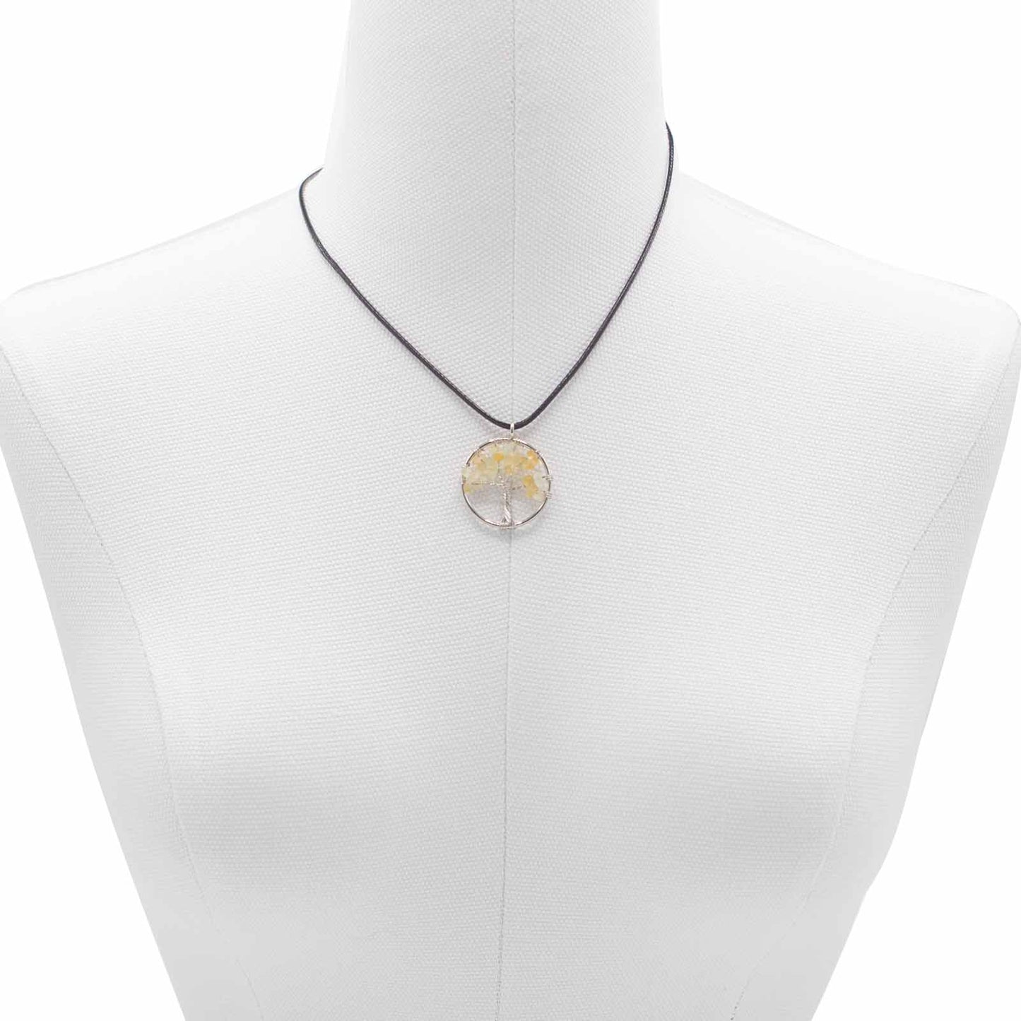 "Tree of Life Pendant featuring a glowing orange Carnelian gemstone, delicately wire-wrapped in silver, suspended on a black cord."