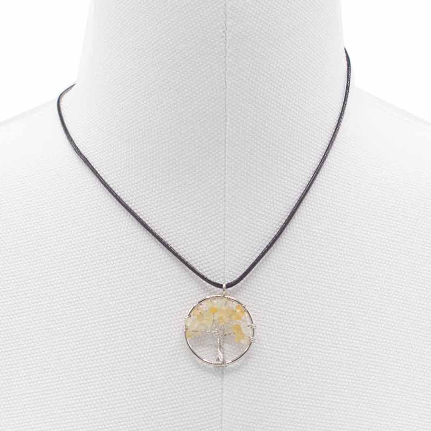 "Tree of Life Pendant featuring a glowing orange Carnelian gemstone, delicately wire-wrapped in silver, suspended on a black cord."