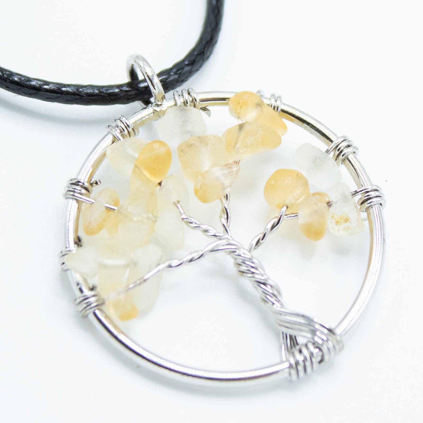 "Tree of Life Pendant featuring a glowing orange Carnelian gemstone, delicately wire-wrapped in silver, suspended on a black cord."