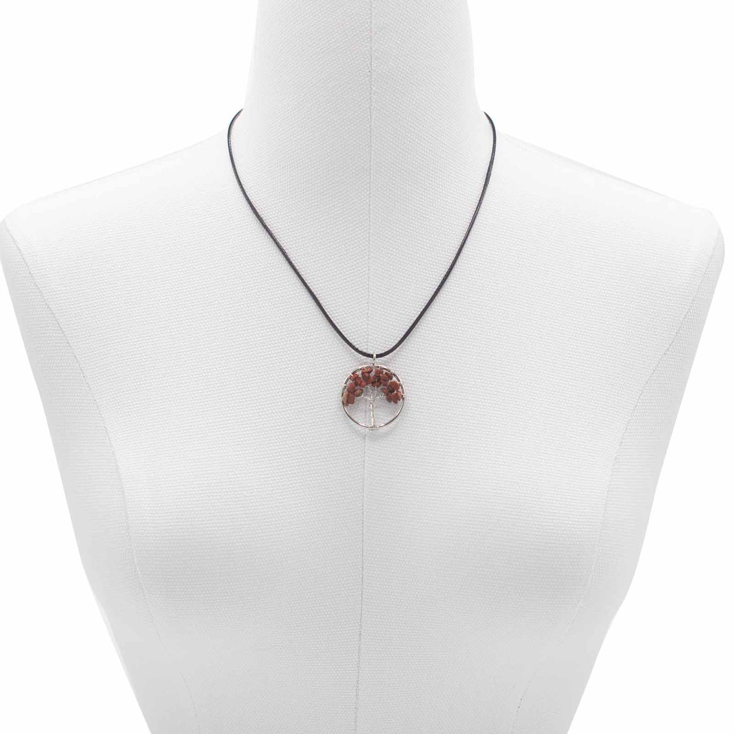 "Tree of Life Pendant featuring a deep red Jasper gemstone in a delicately wire-wrapped silver design, suspended on a black cord."