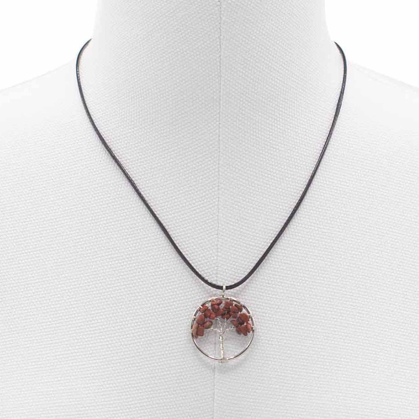 "Tree of Life Pendant featuring a deep red Jasper gemstone in a delicately wire-wrapped silver design, suspended on a black cord."