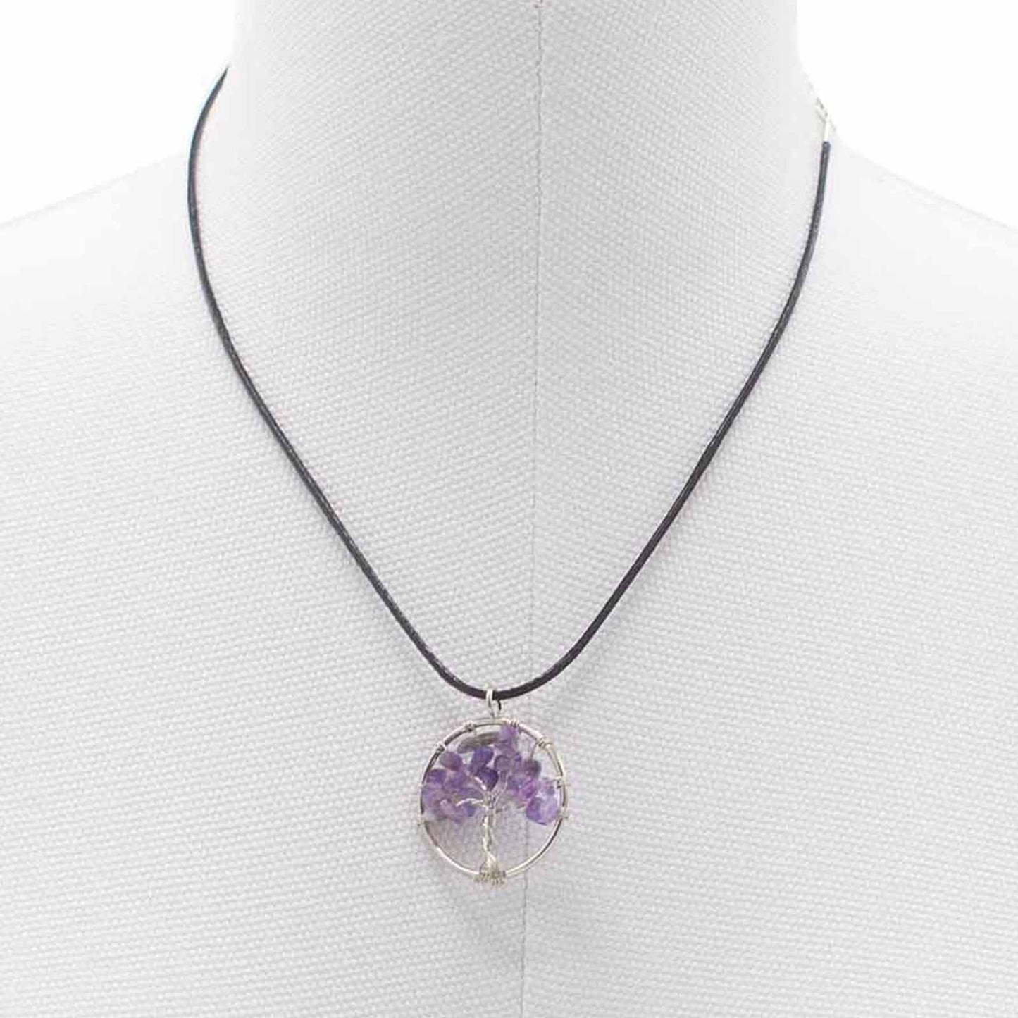 "Tree of Life Pendant featuring a natural Amethyst gemstone in a silver wire-wrapped design, suspended on a black cord."