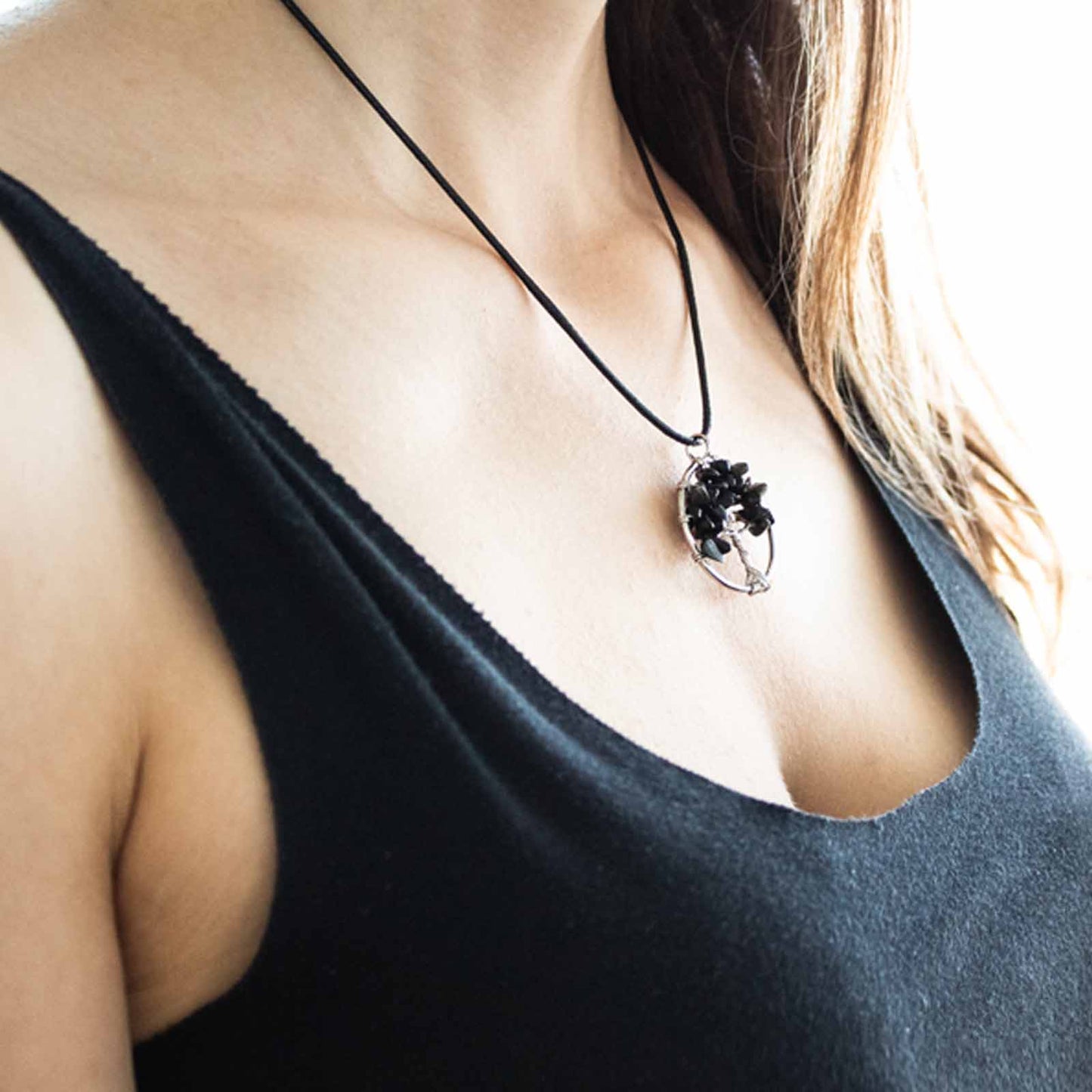 "Tree of Life pendant with black agate gemstone, silver wire-wrapped branches on a black cord necklace."