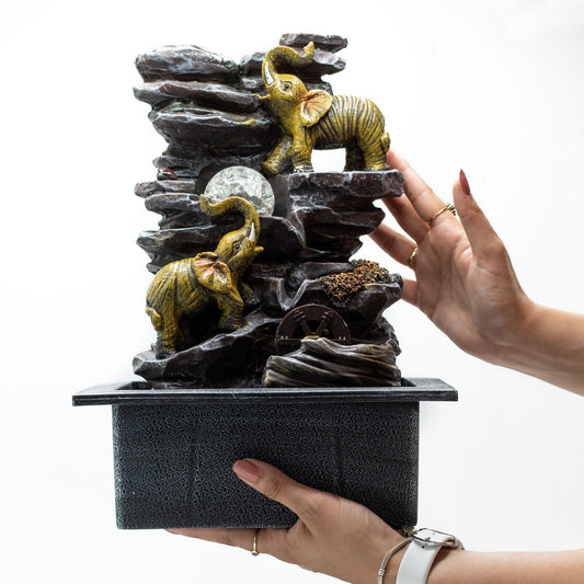 Tabletop Water Feature with elephants, crystal ball, and water wheel on rocky base
