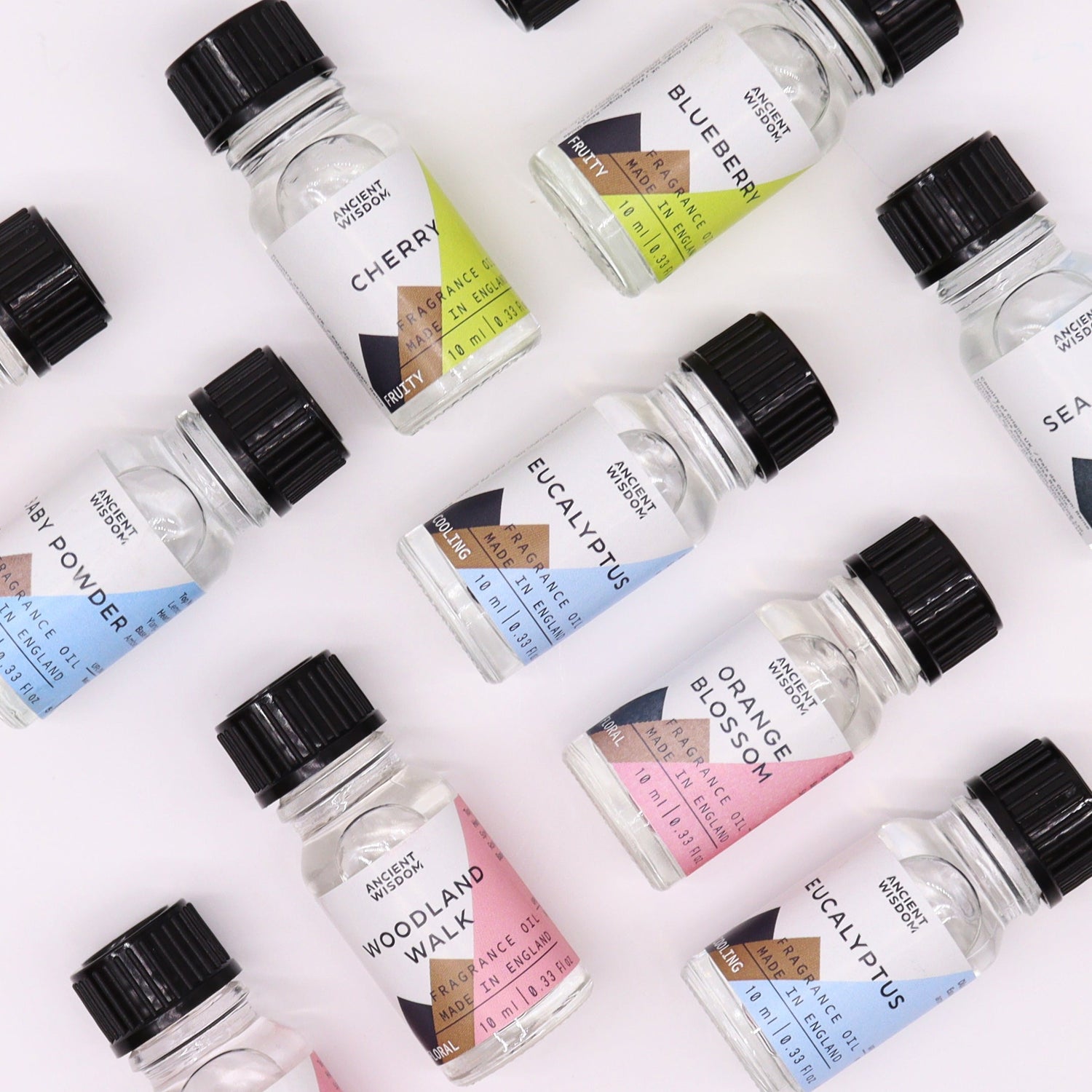 symmetrical display of small bottles of fragrance oil, eucalyptus, orange blossom, cherry and more, clear glass bottles with clear oil