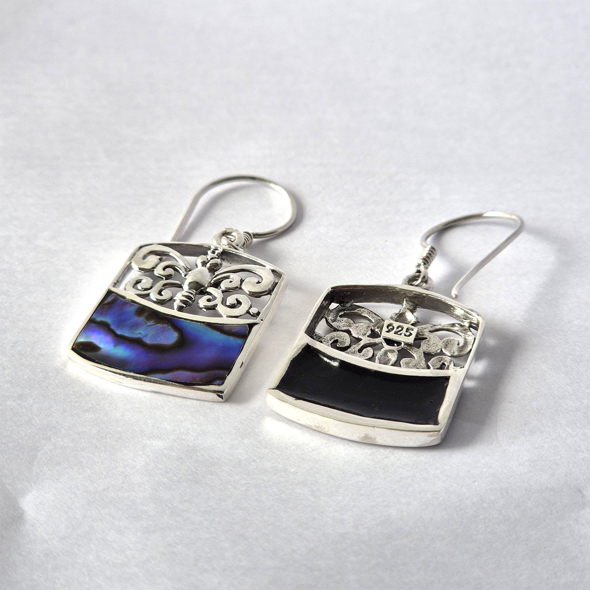 Handmade sterling silver earrings with dragonfly filigree and iridescent abalone shell inlay, displayed on a white background