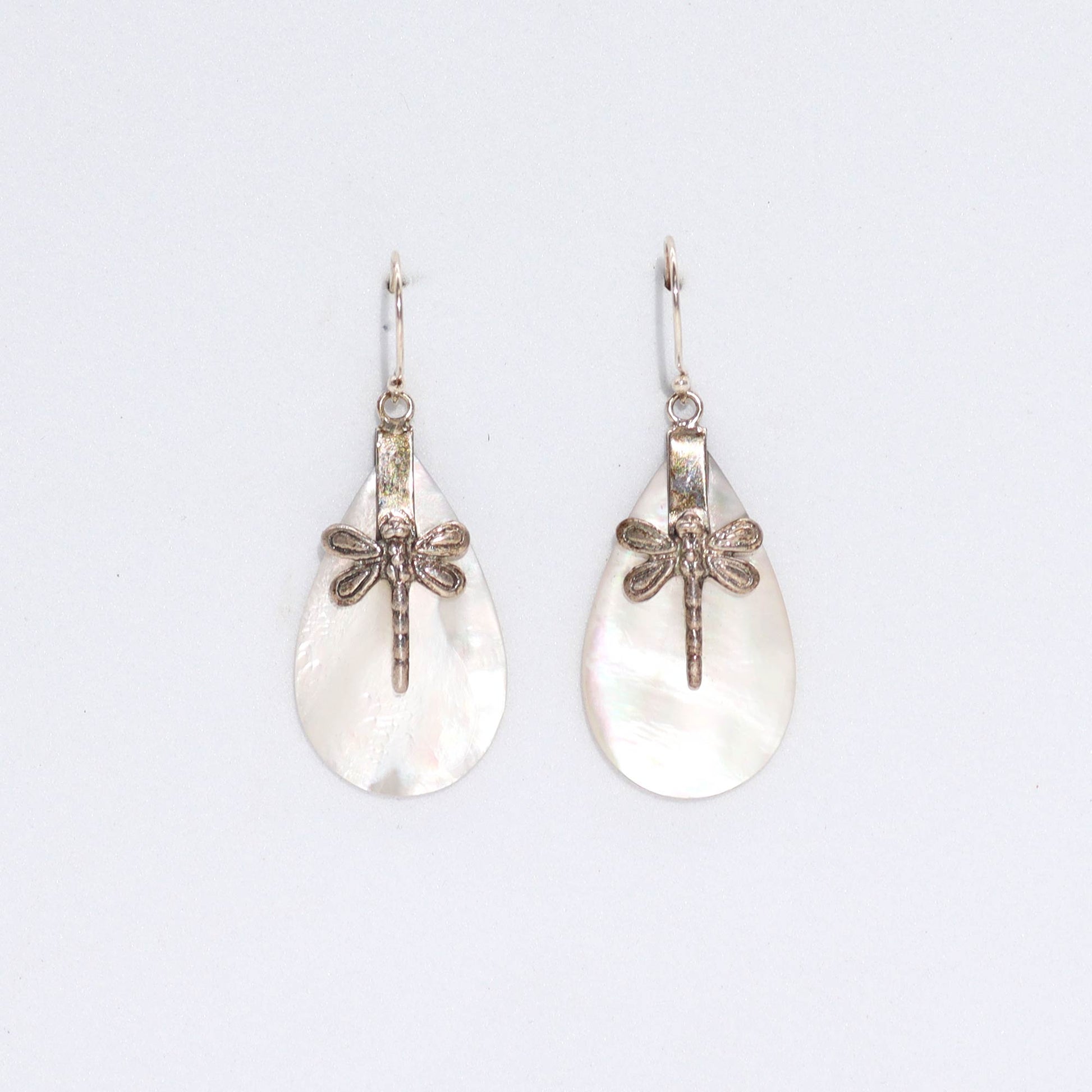 "Teardrop mother of pearl earrings with detailed silver dragonfly overlay, handcrafted in Bali."