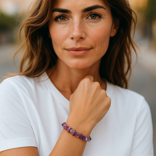 Amethyst chip stone bracelet with soft purple stones, worn by a woman with brown hair and white shirt, symbolising calm, clarity, and spiritual awareness.
