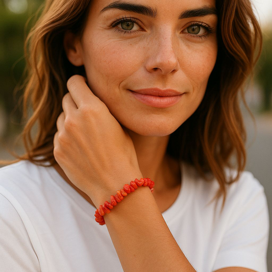 Chip stone bracelet made with redish pink Coralite stones, worn by woman with brown hair and white shirt, symbolising vitality, emotional healing, and inner peace.
