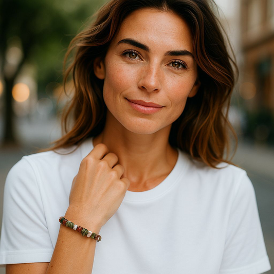 Moss Agate chip stone bracelet with green marbled stones, worn by a woman with brown hair and white shirt, symbolising balance, renewal, and connection to nature.
