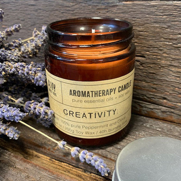 Creativity soy wax aromatherapy candle with peppermint and clove essential oils in amber jar
