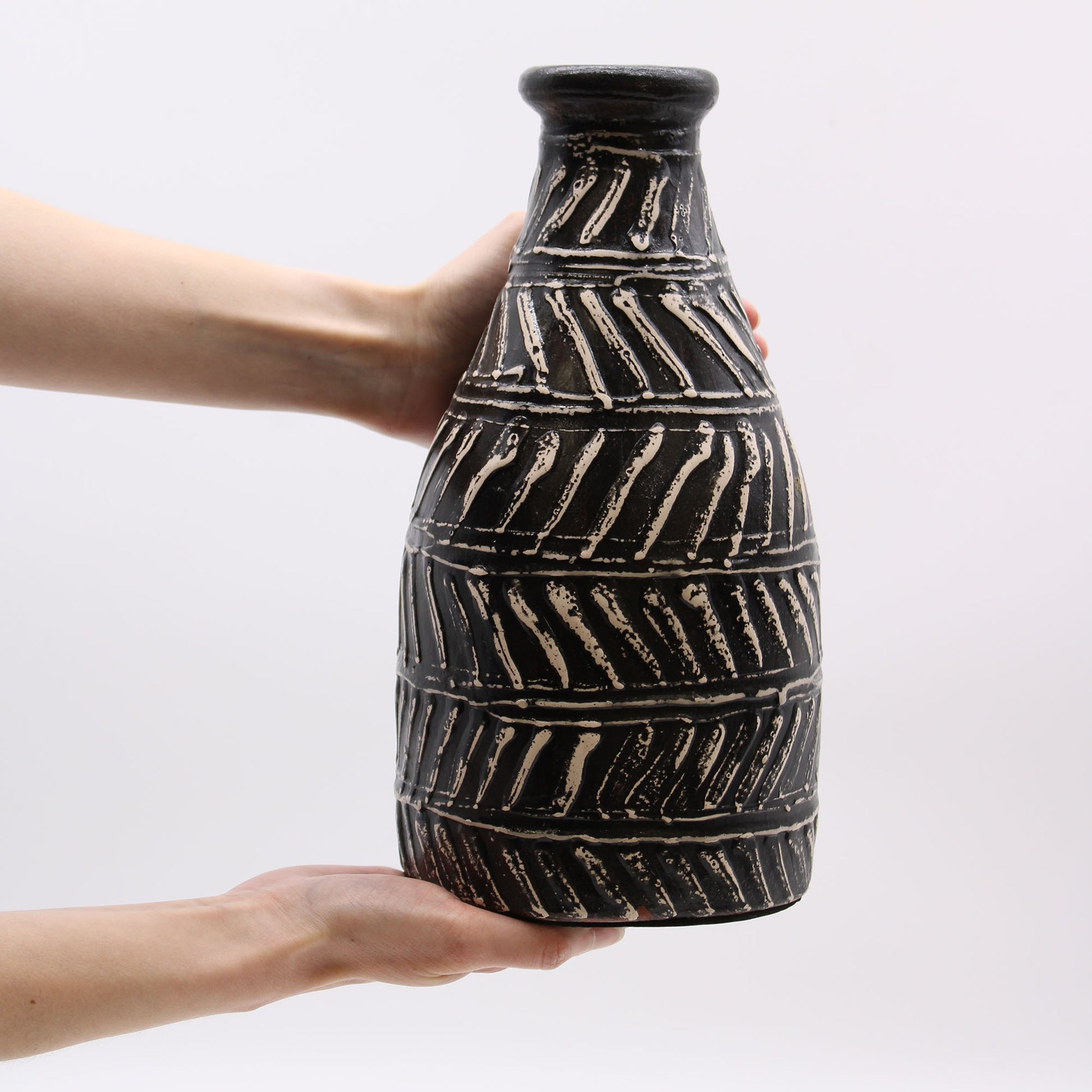 Black terracotta vase with diagonal Greek-style carvings – handcrafted in Lombok, tapered shape, ideal for dried flowers or display.
