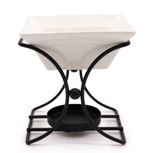 White square ceramic oil burner with black metal stand, modern design for use with tealights and essential oils

