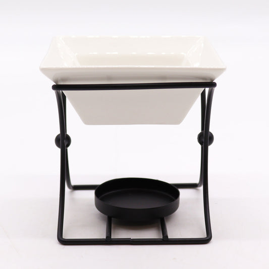 White square ceramic oil burner with black metal stand, modern design for use with tealights and essential oils

