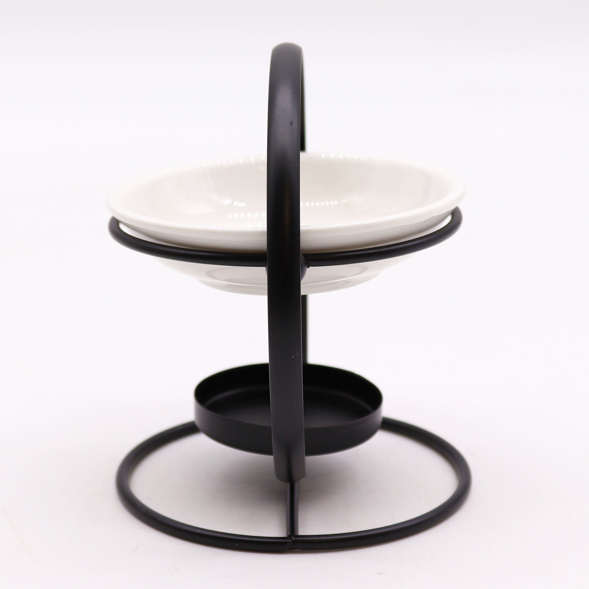 Modern oil burner with white ceramic dish suspended in a black metal hoop stand, designed for essential oils and tealights

