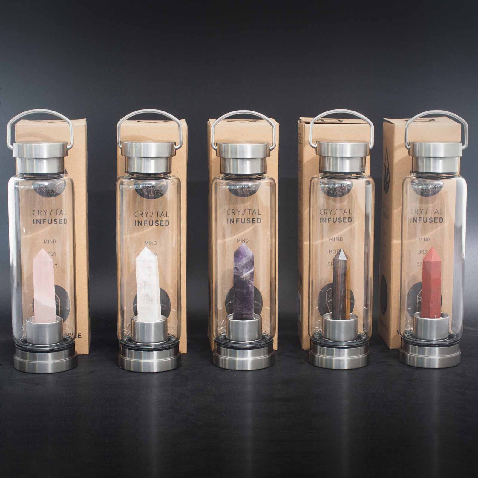 Crystal infused glass bottle with red jasper obelisk, stainless steel lid and base, neoprene sleeve, and gift box. 500ml BPA-free for grounding and vitality.


