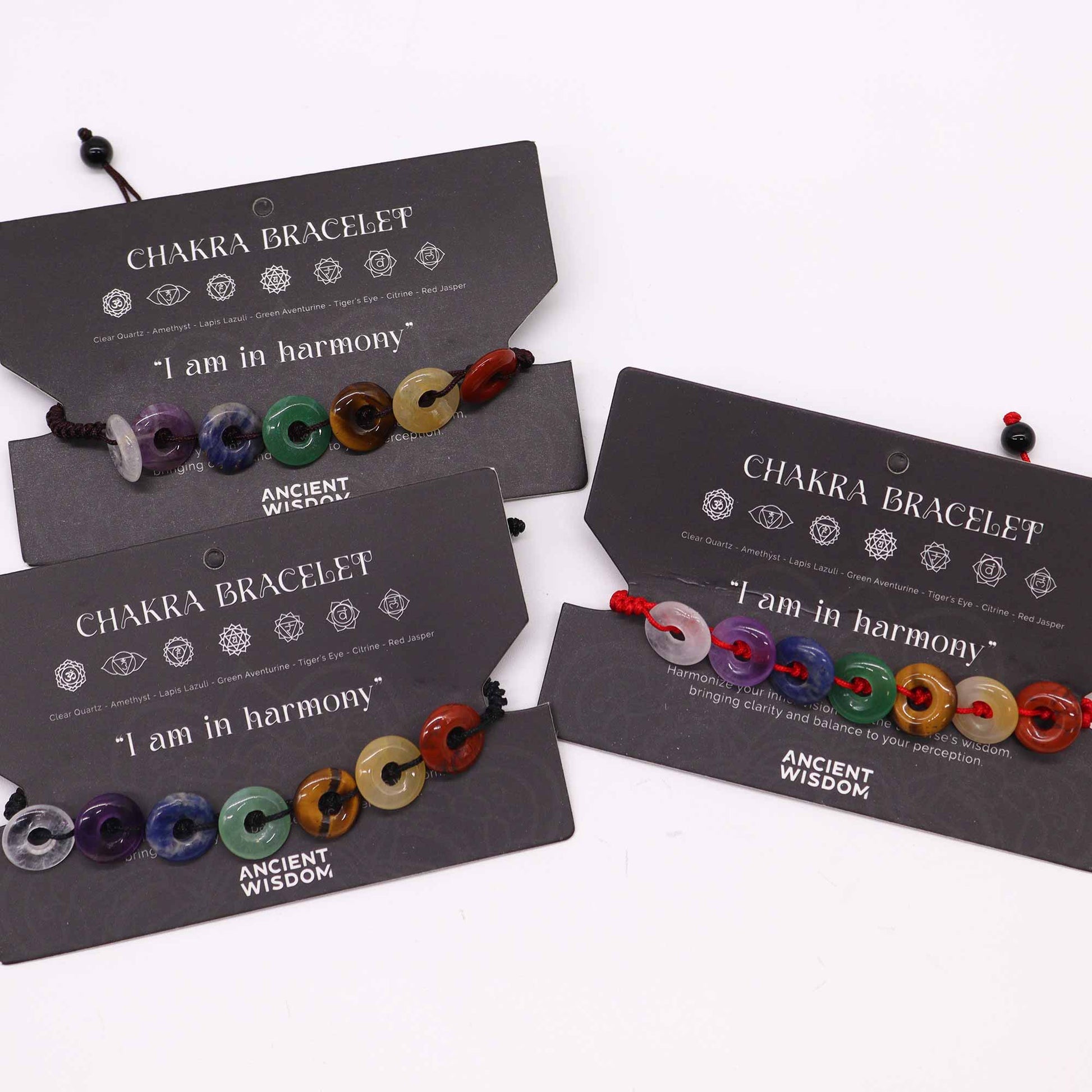 Chakra string bracelet with mini donut-shaped gemstone beads and “I am in harmony” affirmation on adjustable cotton cord.

