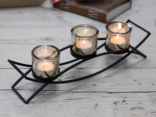Triple iron votive candle holder with curved base and amber glass – modern centrepiece