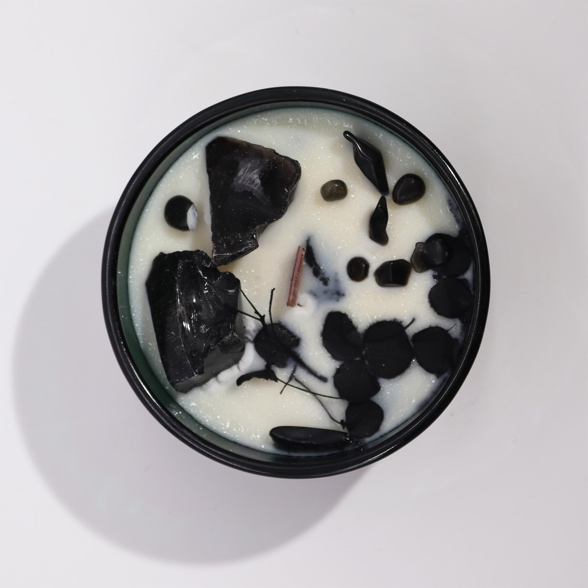 Hop Hare Knight of Swords crystal candle with black obsidian, dried flowers, and tarot card in dark green jar
