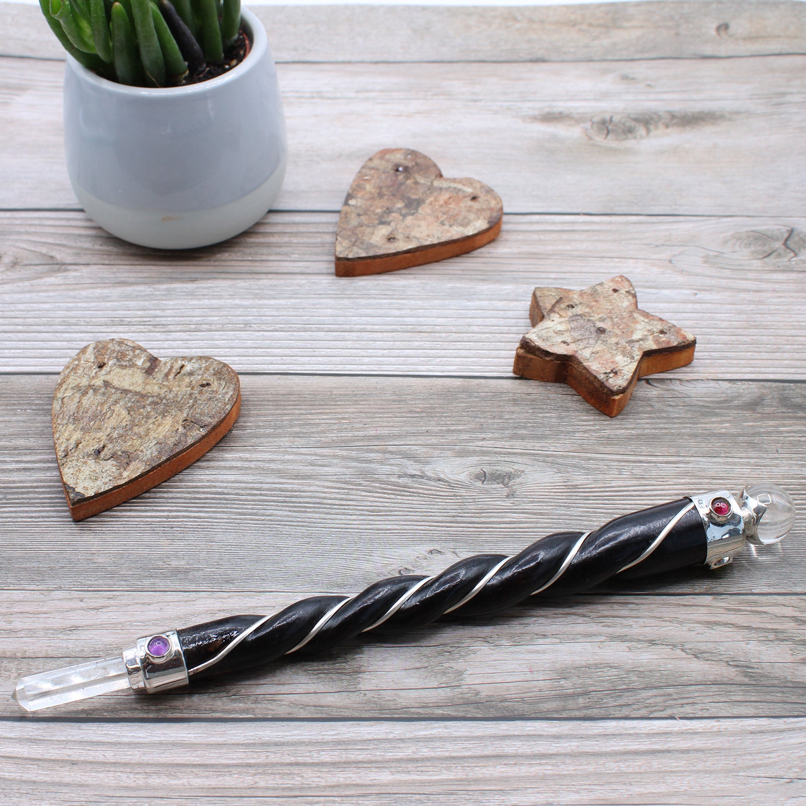 Twisted wooden wand with rock quartz point and sphere, silver plated copper wire, and gemstones. Designed for clarity, energy amplification, and healing.
