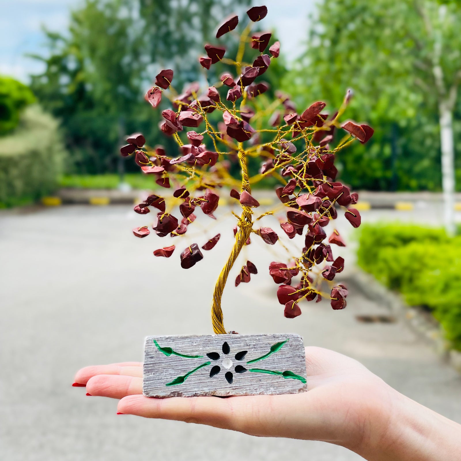 Red jasper crystal tree with carved stone base

