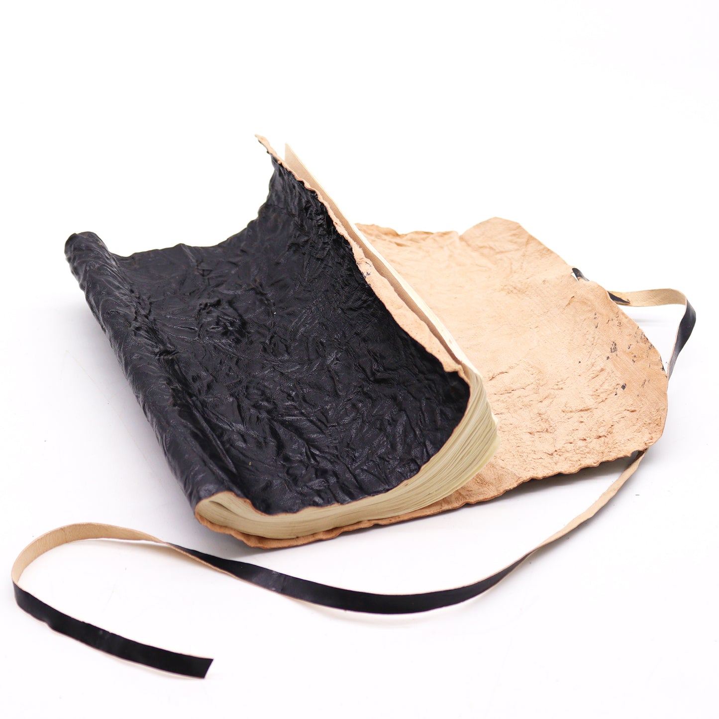 Rolled black leather travel notebook with plain ivory pages, unrolled and ready for writing.

