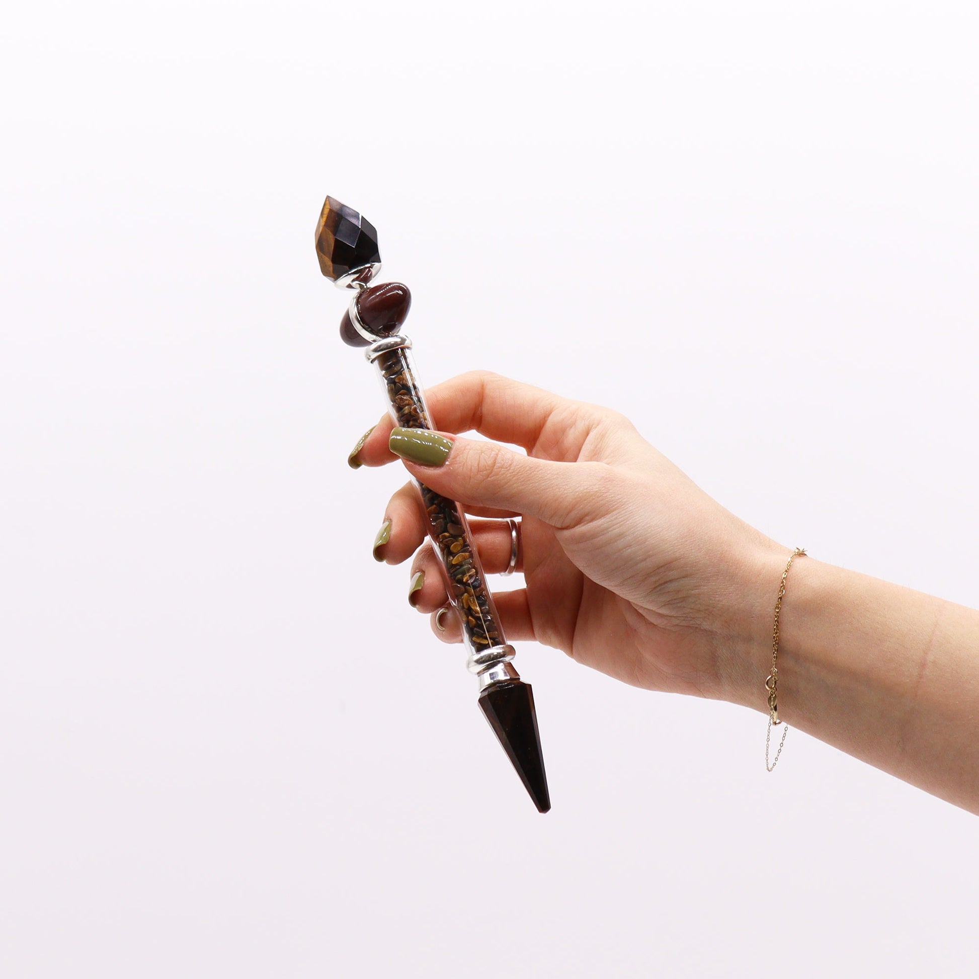Tiger’s Eye Shiva Lingam wand with golden gemstone chips and polished crystal points. Designed for courage, confidence, and grounding energy practices.

