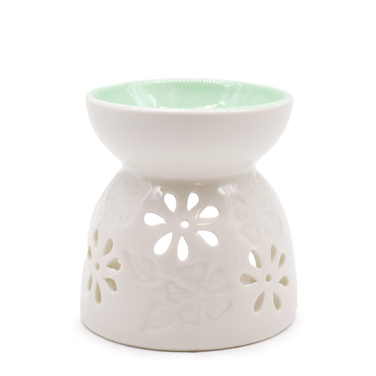 White ceramic oil burner with floral cutouts and mint green bowl – front view

