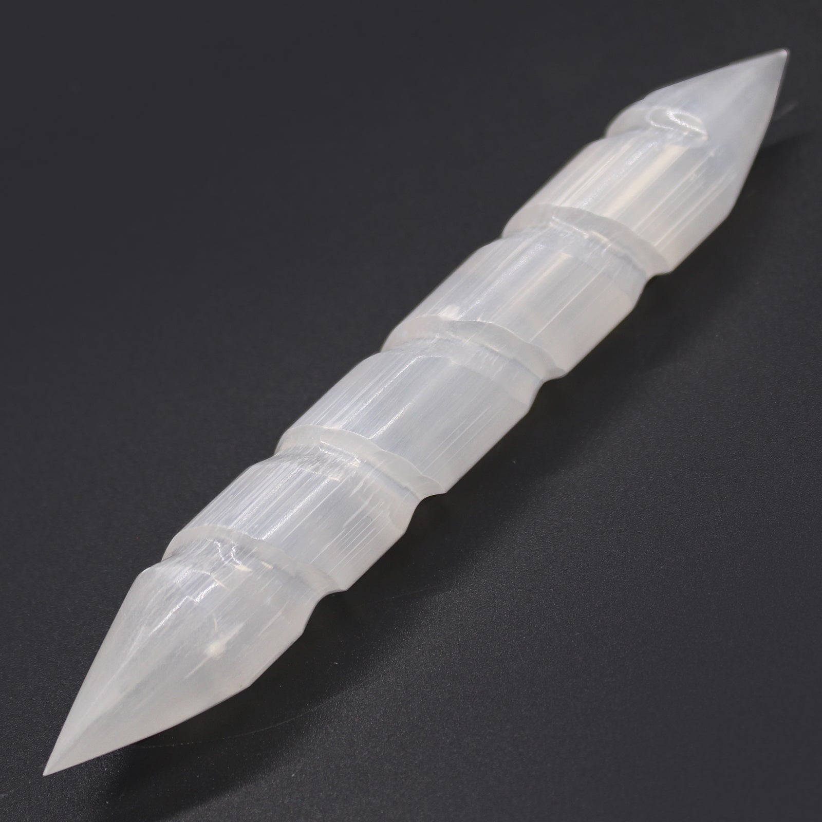 Double-terminated carved Selenite wand with grooved body, hand-cut from Moroccan crystal. Ideal for chakra healing, reiki, and spiritual energy cleansing.

