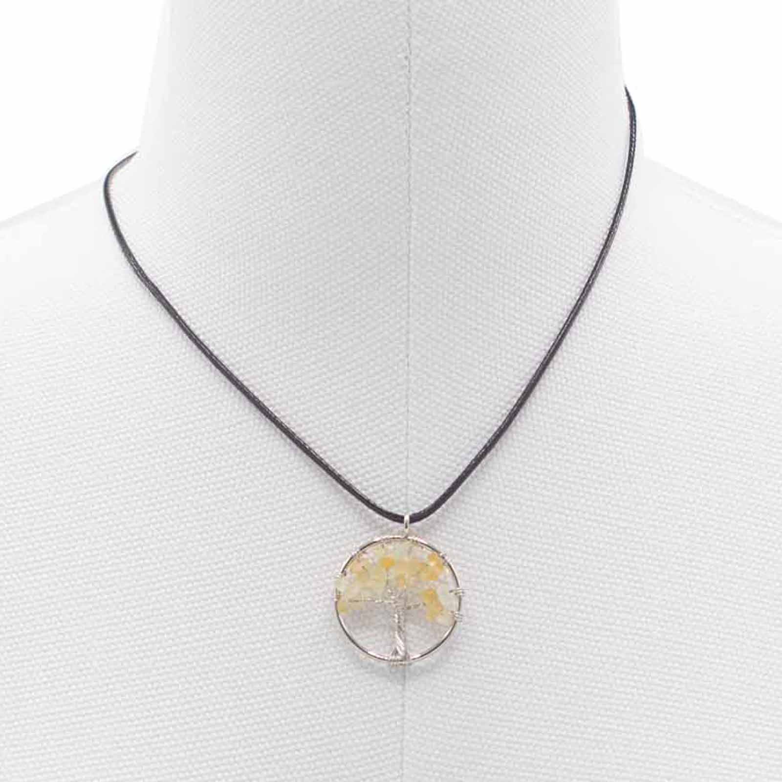 "Tree of Life Pendant featuring a glowing orange Carnelian gemstone, delicately wire-wrapped in silver, suspended on a black cord."

